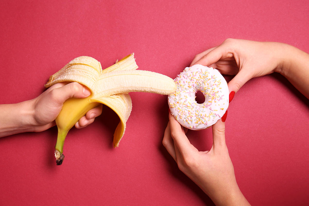Sweet donut and banana in female hands on color background | How To Increase Sex Drive In Easy Steps | sex drive cast