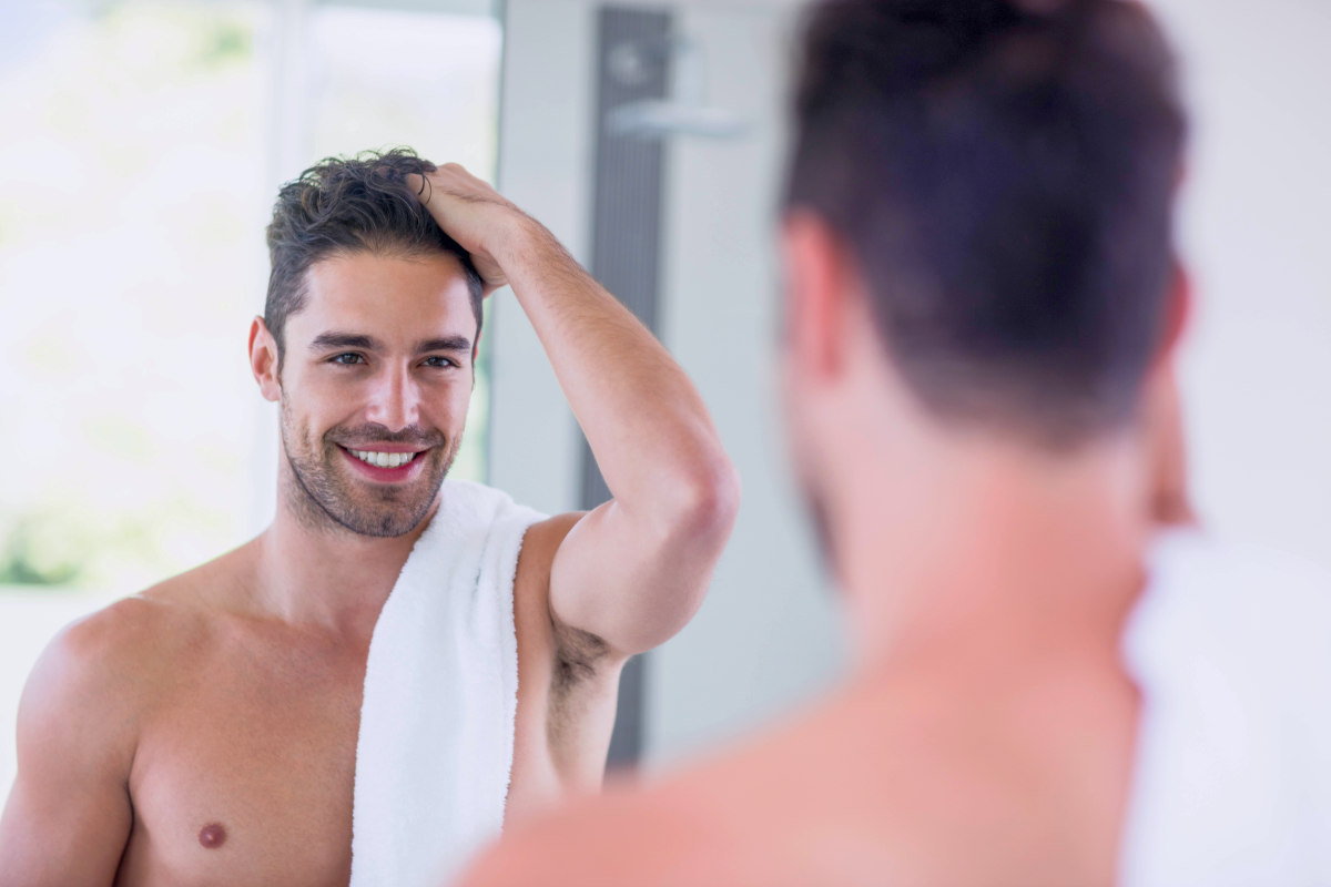 Handsome shirtless man looking in the mirror in the bathroom | Can DHT Blockers Stop Hair Loss? | natural dht blocker
